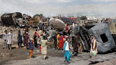 Men walk amidst wreckages of fuel tankers and trucks after an overnight fire, on the outskirts of Kabul. Reuters