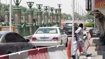 A pedestrian makes his way through the barricades on Takheet street where work is being carried out by Al Ain municipality.