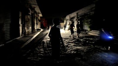 Young boys walk down a dark street in Tripoli, late at night on August 22, 2011. Libyan rebels declared the Kadhafi era over after storming Tripoli, but one of the veteran strongman's sons insisted the battle was far from over as he defiantly refuted rep???