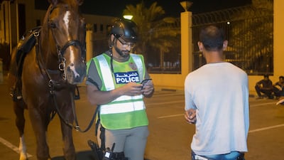 A police officer questions a suspect during his patrol