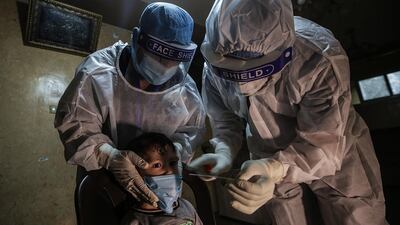 Palestinian medical workers take a swab sample from a child at a home in Al Zaitun neighborhood east Gaza City. EPA