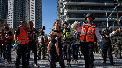 A woman and her child are evacuated from the site of a direct hit from an Iranian missile strike in Ramat Gan, Israel, Thursday, June 19, 2025. (AP Photo / Oded Balilty)