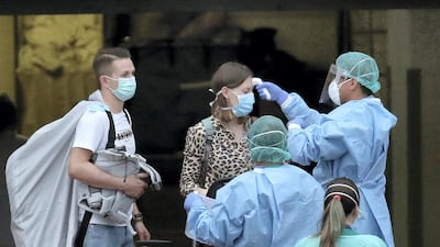 Health personnel wearing protection clothing check the temperature of a guest at the H10 Costa Adeje Palace hotel in La Caleta, in the Canary Island of Tenerife, Spain. AP