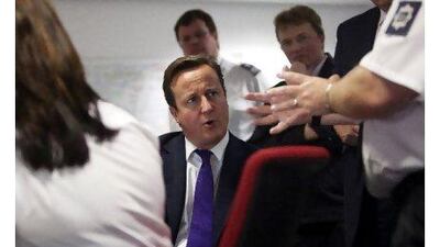Prime minister David Cameron talks to UK border agency officials in their control room during a visit to Heathrow Airport, London yesterday. Mr Cameron's visit to the airport came before his talk on immigration controls. Richard Pohle / WPA Pool / Getty Images