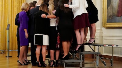US President Donald Trump prays with the Oklahoma Women's Softball women team as he greets members of Championship NCAA teams at the White House in Washington. Joshua Roberts / Reuters