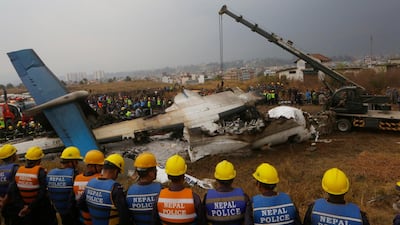 FILE- In this Monday, March 12, 2018 file photo, Nepalese rescuers and police are seen near the debris after a passenger plane from Bangladesh crashed at the airport in Kathmandu, Nepal.Survivors of this week's plane crash at Nepal's main airport said Wednesday that it was a miracle they survived an accident that killed 49 of the 71 people on board. (AP Photo/Niranjan Shreshta, File)