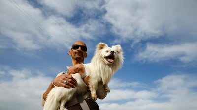 An Iranian man holds his dog, near Turkey's Pazarkule border crossing with Greece's Kastanies, near Edirne, Turkey. Reuters