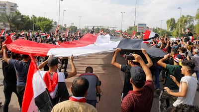 Demonstrators carry huge Iraqi flag during a protest over corruption, lack of jobs, and poor services, in Baghdad, Iraq. Reuters