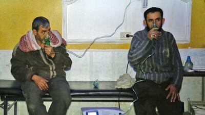 Syrian men wear oxygen masks at a make-shift hospital following a reported gas attack on the rebel-held besieged town of Douma in the eastern Ghouta region on the outskirts of the capital Damascus on January 22, 2018. Hasan Mohamed / AFP