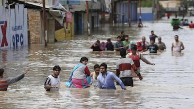 Kashmiri men evacuate women and the elderly from a flooded neighborhood in Srinagar, India on September 7, 2014. Fast-moving floodwaters submerged large parts of the main city in Indian-controlled Kashmir on Sunday after five days of pounding rain. Dar Yasin/AP Photo