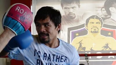 Manny Pacquiao sparring with his coach Freddie Roach as part of his training at a gym in General Santos City in the southern Philipppine island of Mindanao. AFP PHOTO / TED ALJIBE