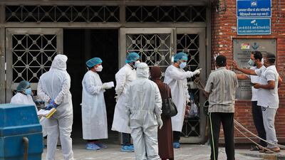 Health workers talk to attendants of a patient at a hospital meant for treating COVID-19 patients in New Delhi, India. AP