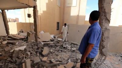 Libyan men inspect a destroyed building in Bani Walid, almost 200 kilometres southeast of Tripoli.