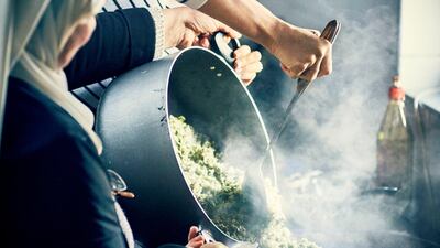 Britain's Meghan, Duchess of Sussex, cooks with women in the Hubb Community Kitchen at the Al Manaar Muslim Cultural Heritage Centre in west London Reuters
