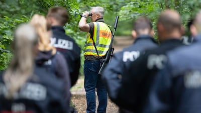 Police officers and a hunter searching in a forest for the suspected lioness. Getty Images