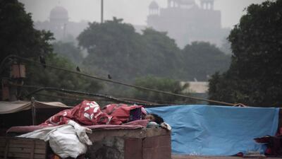 Indian woman sleeps in front of the Red Fort as smog envelop the old quarters of New Delhi on November 6, 2017. / AFP PHOTO / DOMINIQUE FAGET