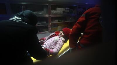 A Syrian girl lies inside an ambulance. Abdulmonam Eassa / AFP Photo