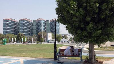 A man finds some shade on the Corniche in Abu Dhabi. Ravindranath K / The National