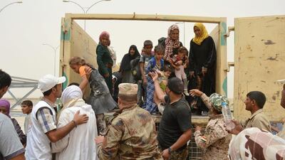 An Iraqi soldier helps civilians, who fled from Fallujah as government forces pressed into the former stronghold of ISIL, on the outskirts of Fallujah, Iraq on June 18, 2016. Reuters