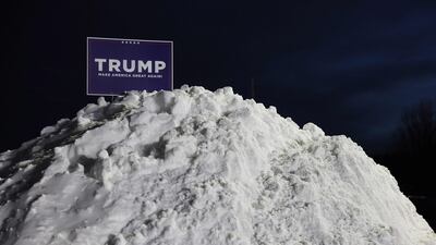 A Trump campaign sign in a snow mound outside the caucus site in Clive. AFP