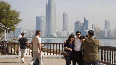 Tourists take photos at Abu Dhabi's Heritage Village. Mona Al-Marzooqi / The National