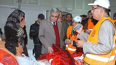 Arab League observers, wearing orange jackets, visit the wounded in the national hospital in Daraa, southern Syria, on Saturday. The observers are inspecting hotspots across the country.