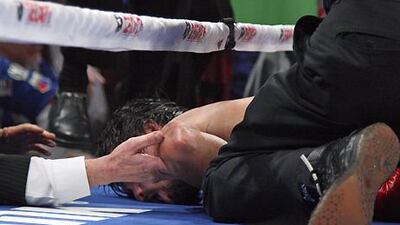 Prone boxer Manny Pacquiao receives aid after being knocked out by Juan Manuel Marquez.