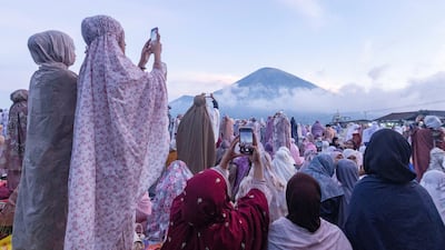 Indonesian women take pictures of the Mount Sindoro volcano before mass Eid Al Adha prayers in Wonosobo, Central Java. Reuters