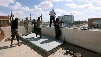 Libyan militia fighters aligned with the defence ministry celebrate on top of a building in the centre of the former Qaddafi stronghold of Bani Walid.
