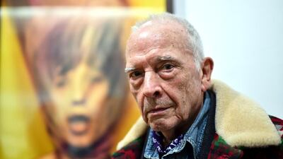 British photographer David Bailey poses in front of his picture of Mick Jagger. Gabriel Bouys / AFP