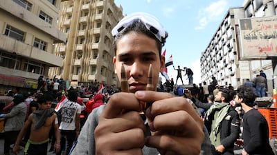 An Iraqi protester holds live ammunition which was allegedly used by security forces during clashes with protesters at the Al-Khilani square in central Baghdad, Iraq. EPA