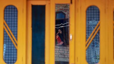 A girl's reflection is seen in a mirror in Kashmir. Farooq Khan / EPA