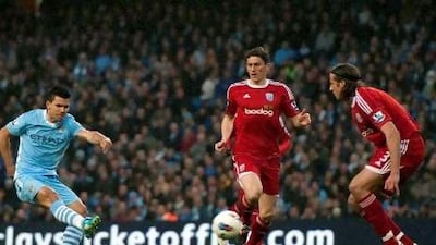 Manchester City’s striker Sergio Aguero, left, scores the opening goal of the game against West Bromwich Albion at Etihad Stadium last night.