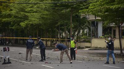 Forensic police examine the site after a suspected bomb exploded near a church in Makassar. AFP