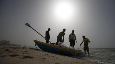 Palestinian fishermen prepare their nets during sunset along a beach in Gaza City. AFP