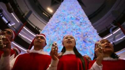 Shoppers play in front of the 29-metre tall Christmas tree at Dubai Mall.