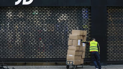 A delivery courier waits with boxes outside a JD Sports Fashion store on London's Oxford Street. People are consuming fashion more quickly, more often and at much lower price points, says Janus Henderson's Charlotte Nisbet. Bloomberg