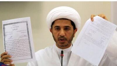 Sheik Ali Salman, head of the Shiite opposition al-Wefaq party in Bahrain, holds up documents during a press conference this month about the opposition's terms for negotiations with the Bahraini government.