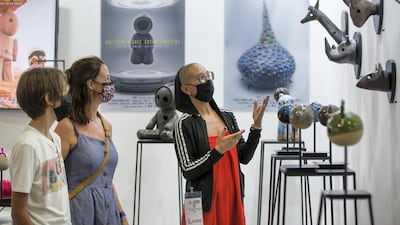 Artist Griet Van Den Auwelant showing her artworks to the visitors at the World Art Dubai at Dubai World Trade Centre. Leslie Pableo / The National