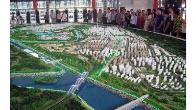 Visitors look at a model of the eco-city under construction near the port city of Tianjin.