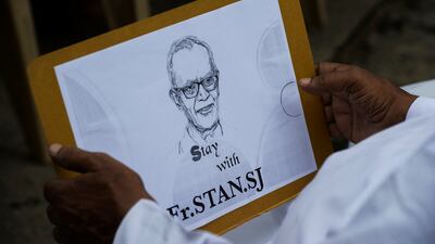 A Catholic priest holds a placard bearing the image of Father Stan Swamy during a protest against the Jesuit's arrest in October 2020.