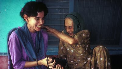 Kirin Narayan shares a recording on a Walkman cassette player with one of the elderly Kangri singers, Janaka-devi. Courtesy University of Chicago Press