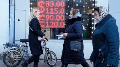 People walk past a currency exchange in Moscow. Ordinary Russians are facing the prospect of higher prices amid a plummeting rouble. AP Photo