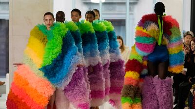 Five models all wearing the same long outfit at Tomo Koizumi. AP