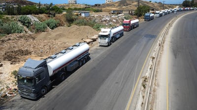 Lorries are loaded with Iraqi crude oil on the Mediterranean coast of Syria. Ahmad Fallaha / The National