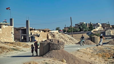 Civilians walk near Syrian government forces stationed on the front line in the countryside of Syria's northern city of Manbij, located near the border with Turkey. AFP