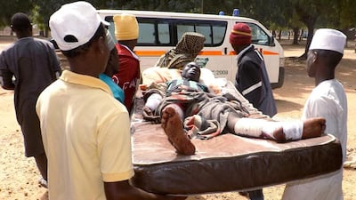 Relatives carry a man injured in a suicide blast in north-east Nigerian town of Potiskum on January 12, 2015. Aminu Abubakar / AFP