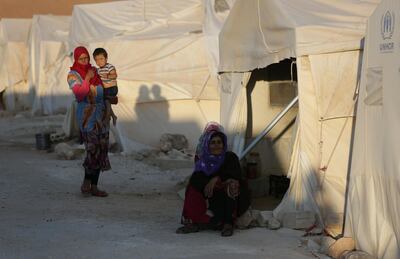 An internally displaced woman sits outside a tent in Syria's Idlib province. Reuters