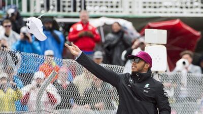 Lewis Hamilton tosses hats at spectators before the start of Sunday's Hungarian Grand Prix. Graham Hughes / AP Photo
