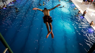 An Iraqi youth dives into a swimming pool to cool off, as temperature rises in Mosul. Reuters